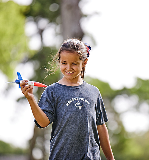 girl playing with model rocket